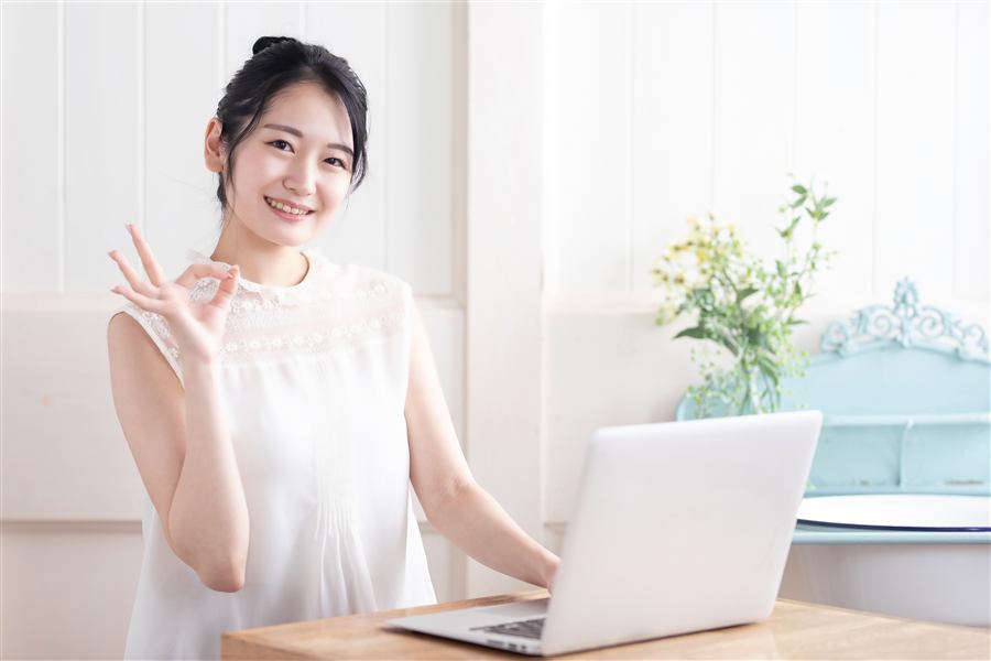 笑顔でパソコンを操作する女性